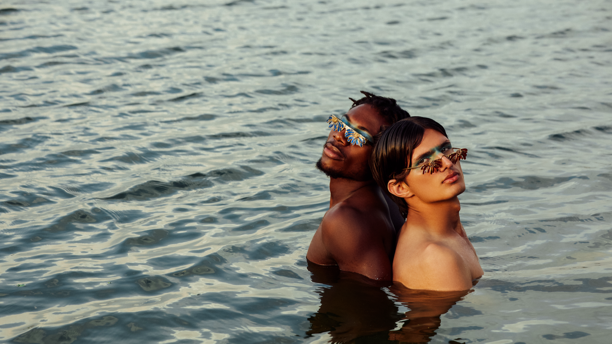 Two people in the water wearing sunglasses